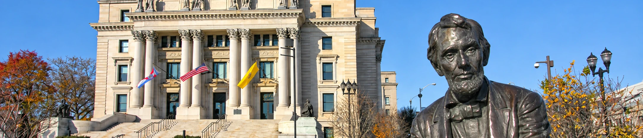 Seated bronze statue of Abraham Lincoln in front of a columned courthouse